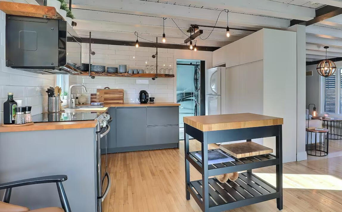 Cuisine moderne du Chalet Le Monarque près de Magog avec îlot central et plancher de bois